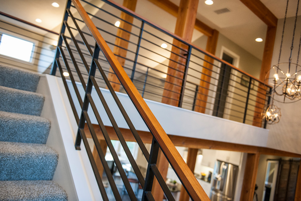 Mittelgroße Industrial Treppe in L-Form mit Teppich-Treppenstufen, Teppich-Setzstufen und Stahlgeländer in Sonstige