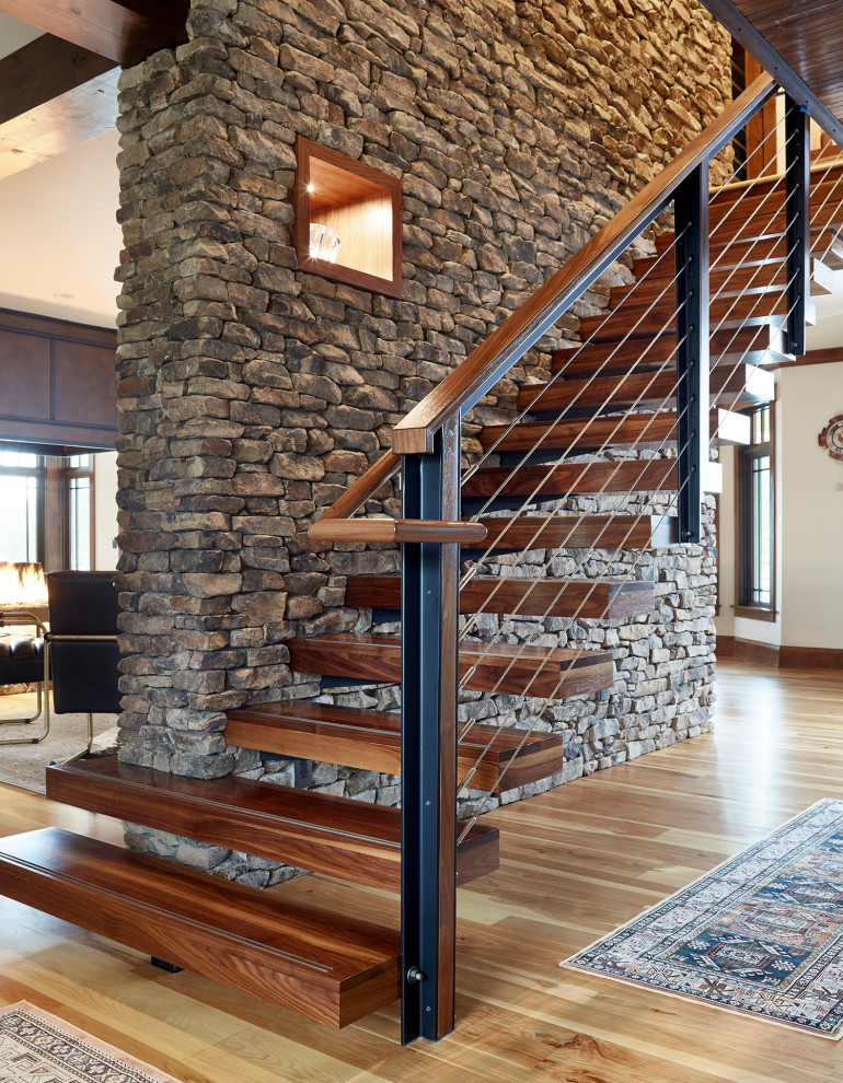 Idée de décoration pour un escalier flottant minimaliste de taille moyenne avec des marches en bois et un garde-corps en câble.