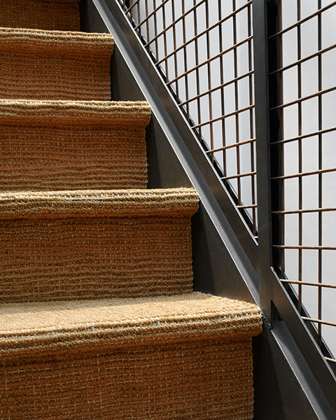 Foto de escalera en U minimalista de tamaño medio con escalones enmoquetados y contrahuellas de madera