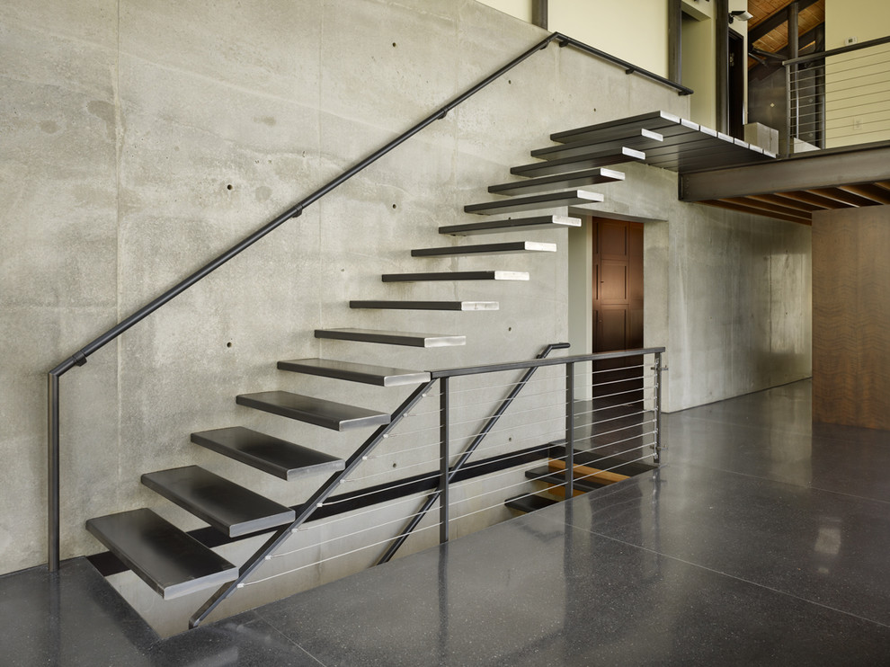 Example of an urban metal railing staircase design in Seattle