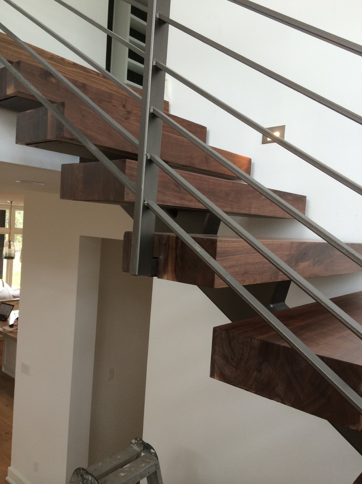 Ejemplo de escalera suspendida industrial de tamaño medio con escalones de madera y contrahuellas de madera