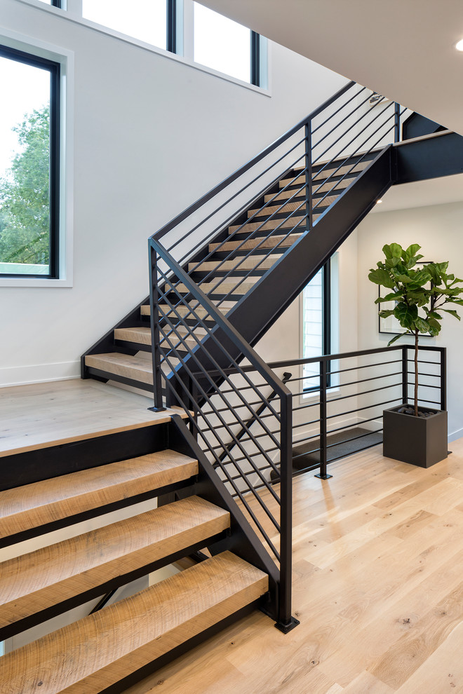 Modelo de escalera en U contemporánea de tamaño medio con escalones de madera, contrahuellas de metal y barandilla de metal