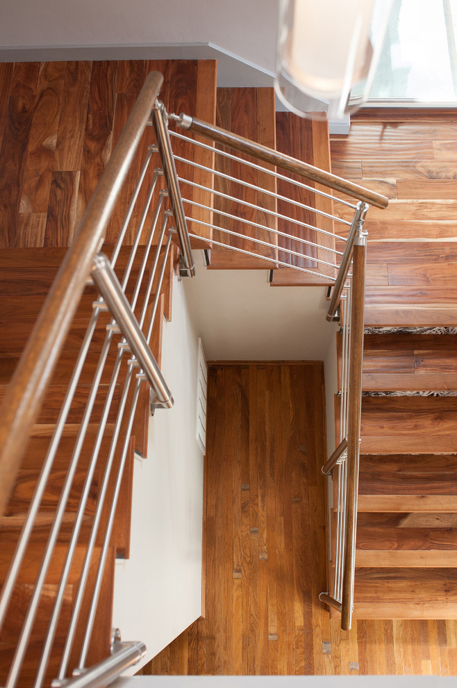 Modelo de escalera en L retro de tamaño medio con escalones de madera, contrahuellas de madera pintada y barandilla de metal