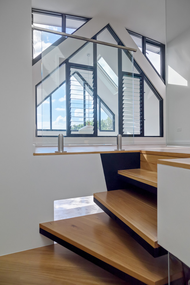 Modelo de escalera en L contemporánea pequeña con escalones de madera, contrahuellas de madera y barandilla de vidrio