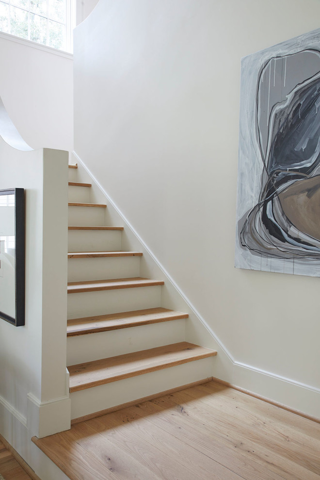 Imagen de escalera clásica con escalones de madera y contrahuellas de madera pintada