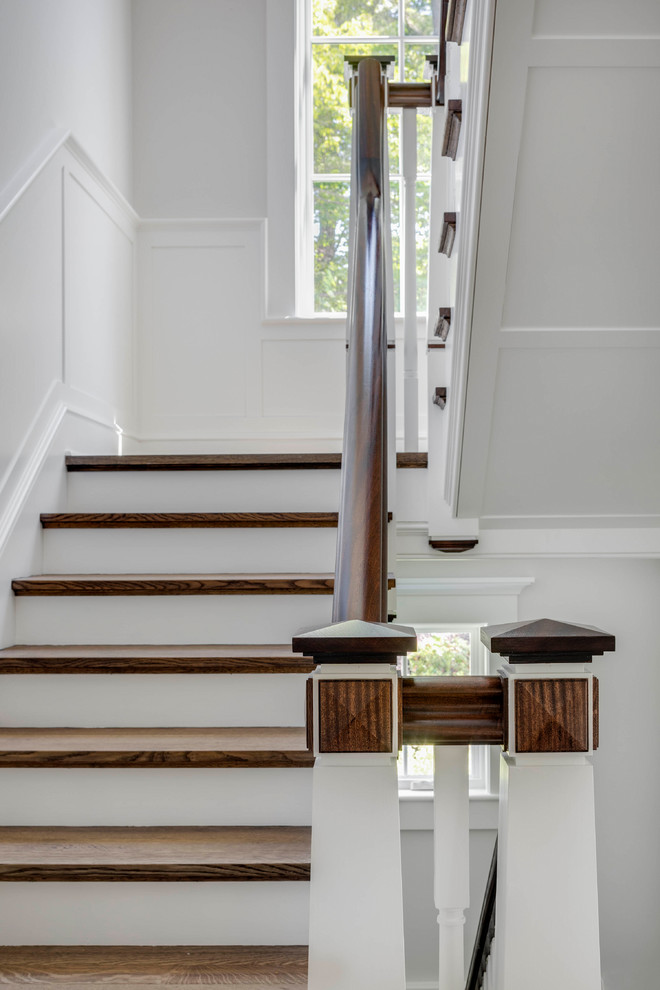 Example of a large classic wooden u-shaped wood railing staircase design in Boston with painted risers