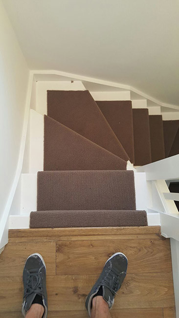 Medium sized classic carpeted u-shaped wood railing staircase in London with carpeted risers.