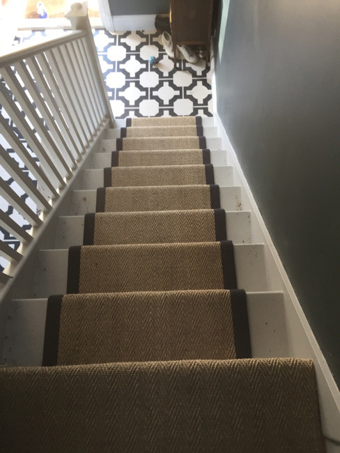 Example of a mid-sized mountain style carpeted u-shaped wood railing staircase design in London with carpeted risers