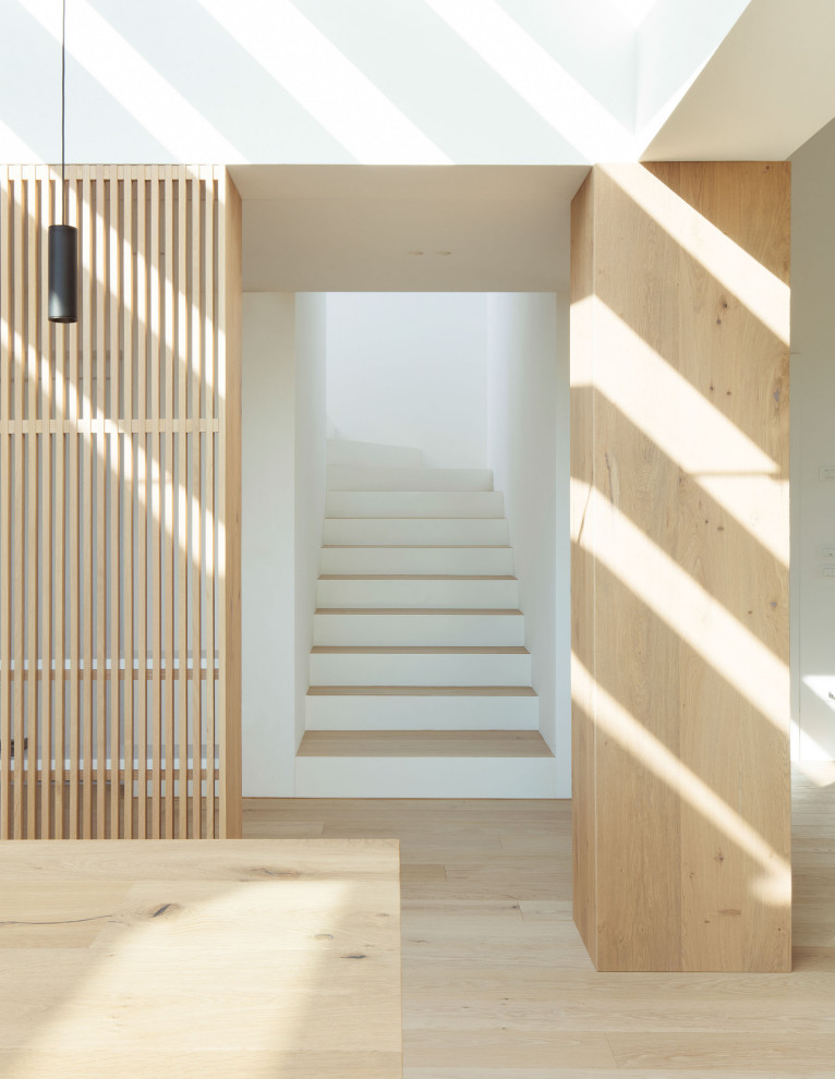 Ejemplo de escalera en L contemporánea de tamaño medio con escalones de madera y contrahuellas de metal