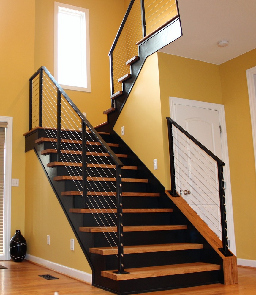 Staircase - mid-sized industrial wooden u-shaped cable railing staircase idea in Detroit with wooden risers