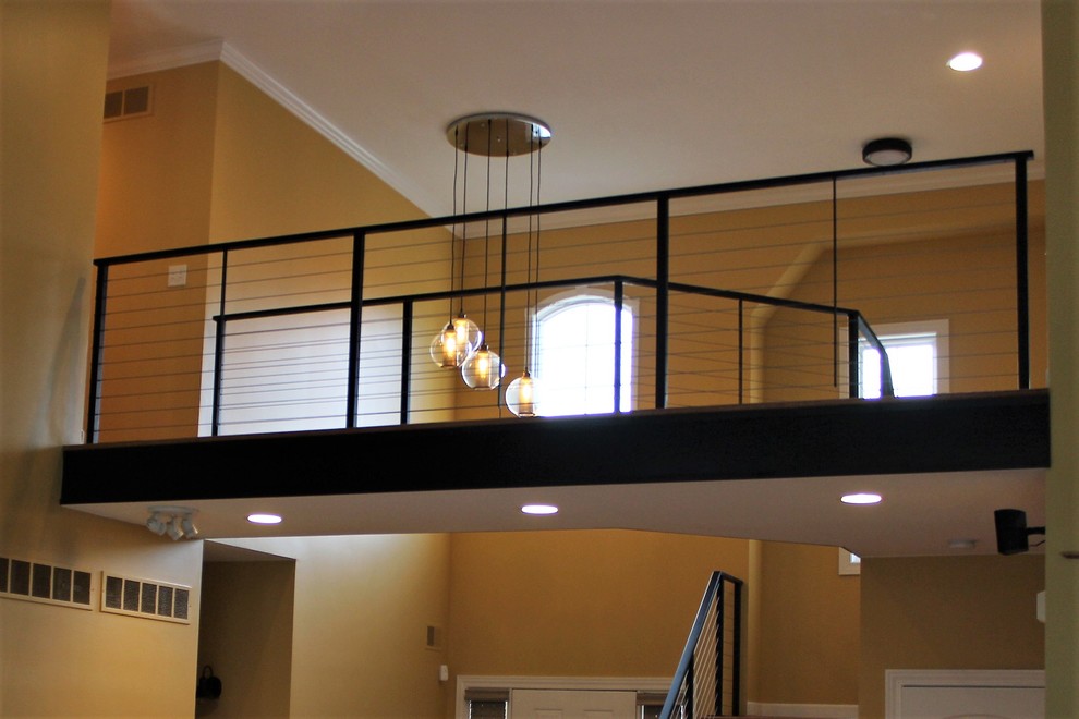 This is an example of a medium sized urban wood u-shaped wire cable railing staircase in Detroit with wood risers.