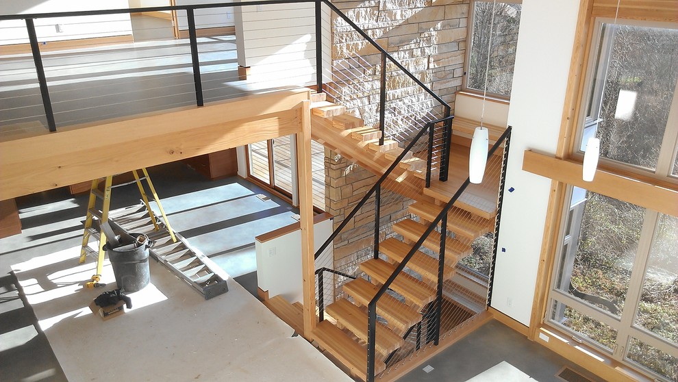 Foto de escalera en U contemporánea de tamaño medio sin contrahuella con escalones de madera