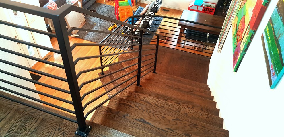 Ejemplo de escalera curva escandinava de tamaño medio con escalones de madera, contrahuellas de madera y barandilla de metal