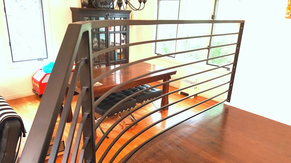Inspiration for a large scandinavian wooden curved metal railing staircase remodel in Denver with wooden risers