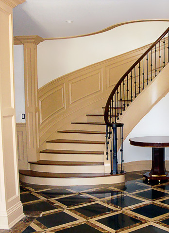 Réalisation d'un escalier peint courbe victorien de taille moyenne avec des marches en bois peint et un garde-corps en métal.