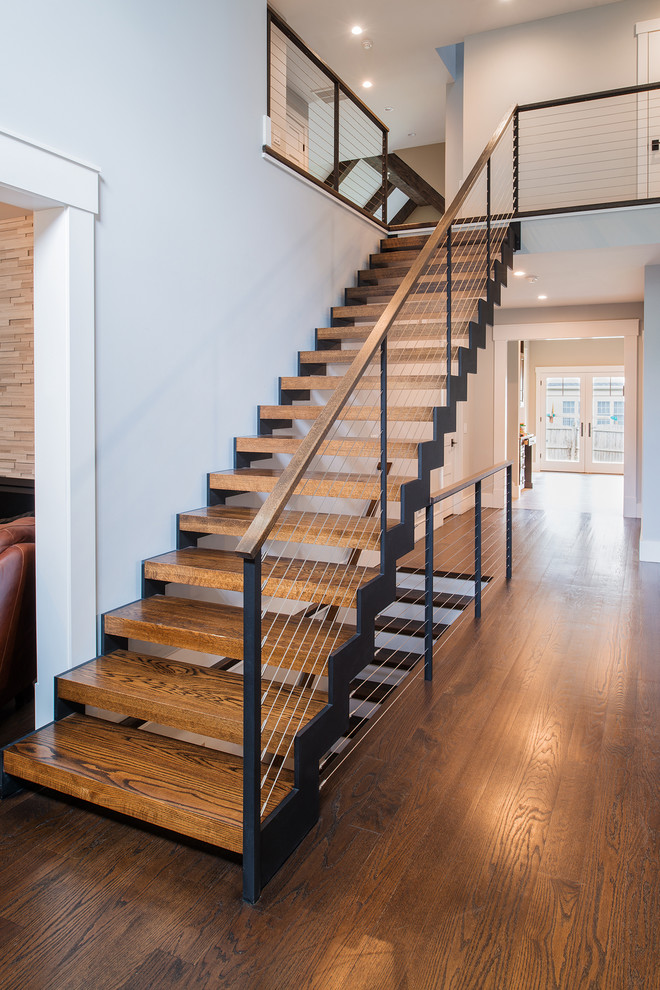На фото: лестница среднего размера в классическом стиле с деревянными ступенями и перилами из тросов с