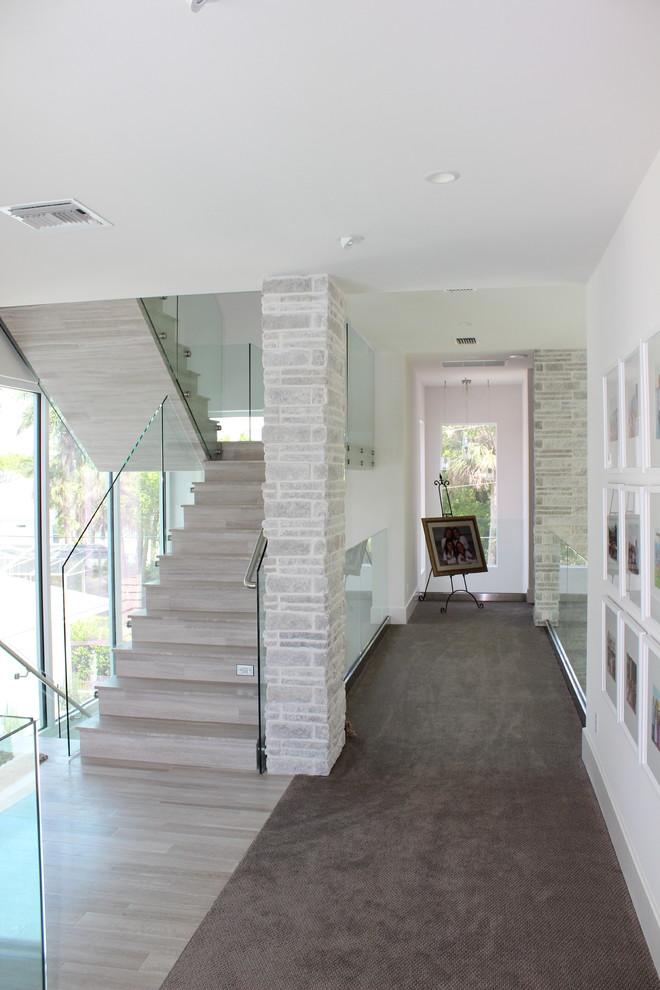 Ejemplo de escalera actual de tamaño medio con escalones con baldosas, contrahuellas con baldosas y/o azulejos y barandilla de metal