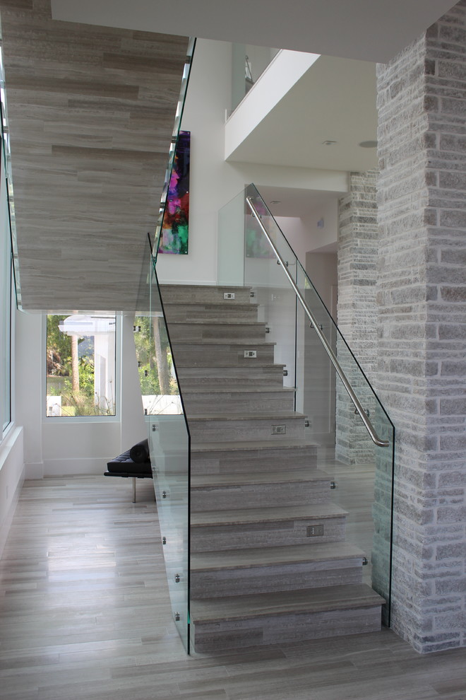 На фото: лестница среднего размера в современном стиле с ступенями из плитки, подступенками из плитки и металлическими перилами