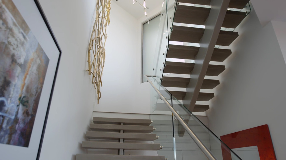 Свежая идея для дизайна: огромная лестница на больцах в стиле модернизм с деревянными ступенями без подступенок - отличное фото интерьера