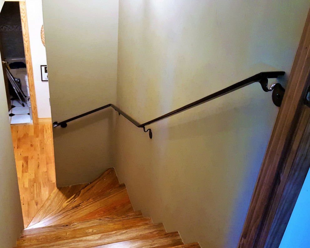 Modelo de escalera curva de tamaño medio con escalones de madera, barandilla de metal y contrahuellas de madera