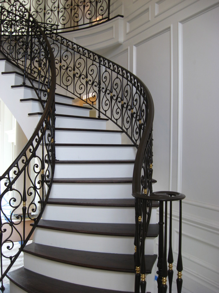 Mid-sized elegant wooden curved staircase photo in New York with painted risers