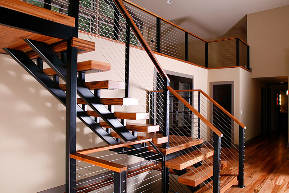 Cette photo montre un escalier sans contremarche tendance en L de taille moyenne avec des marches en bois et un garde-corps en câble.