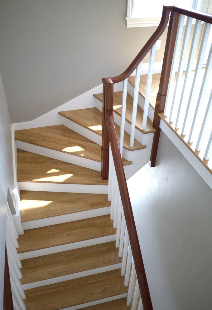 Example of a mid-sized wooden curved staircase design in Providence with painted risers