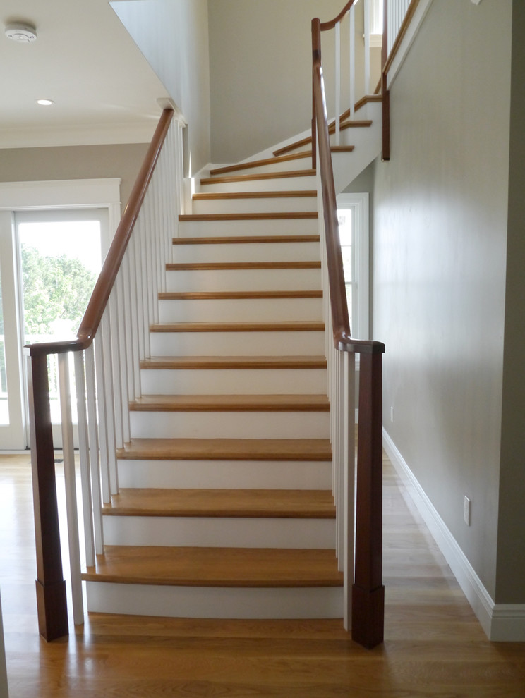 Modelo de escalera curva actual de tamaño medio con escalones de madera y contrahuellas de madera pintada