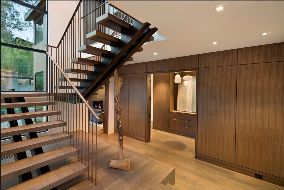 Ejemplo de escalera en U contemporánea de tamaño medio sin contrahuella con escalones de madera y barandilla de metal