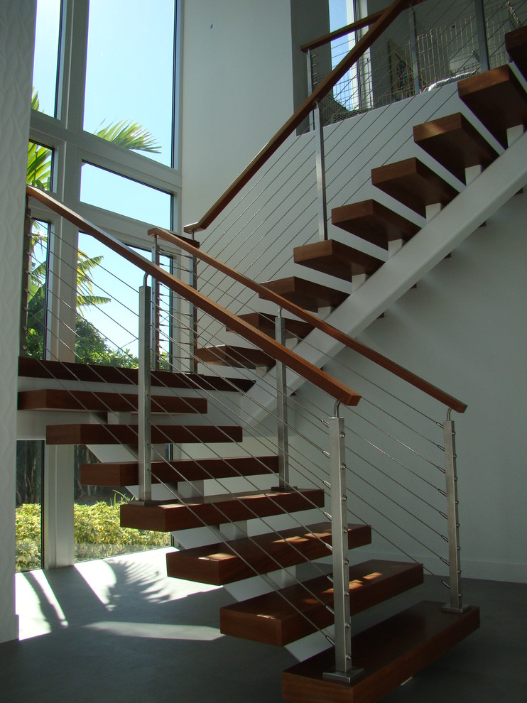 На фото: маленькая угловая лестница в современном стиле с деревянными ступенями и перилами из тросов для на участке и в саду