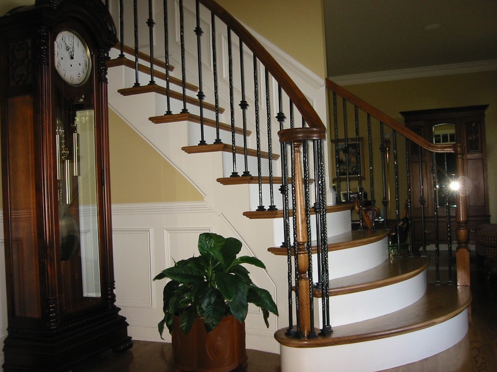 Traditional wood curved staircase in Boston with wood risers.