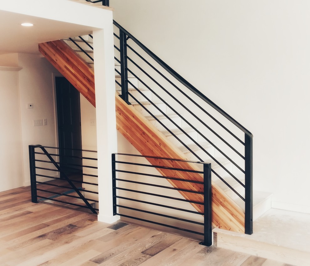 Inspiration för mellanstora moderna l-trappor i målat trä, med räcke i metall och sättsteg i betong