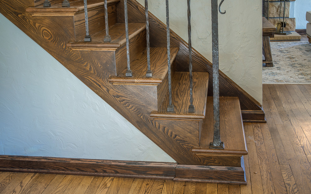 Idée de décoration pour un escalier droit tradition de taille moyenne avec des marches en bois, des contremarches en bois et un garde-corps en métal.