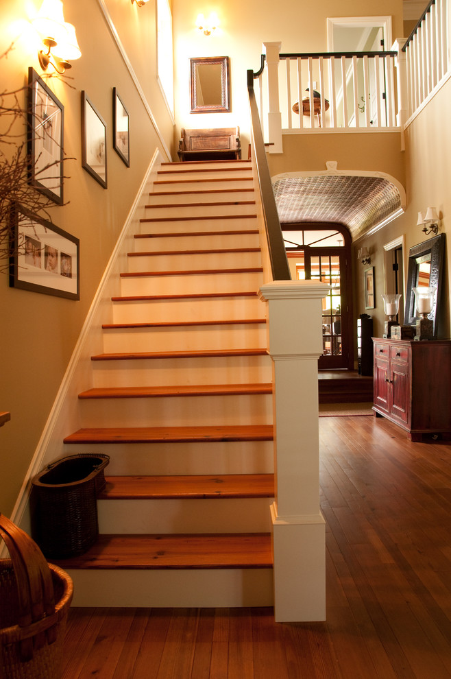 Imagen de escalera recta rural de tamaño medio con escalones de madera, contrahuellas de madera pintada y barandilla de madera