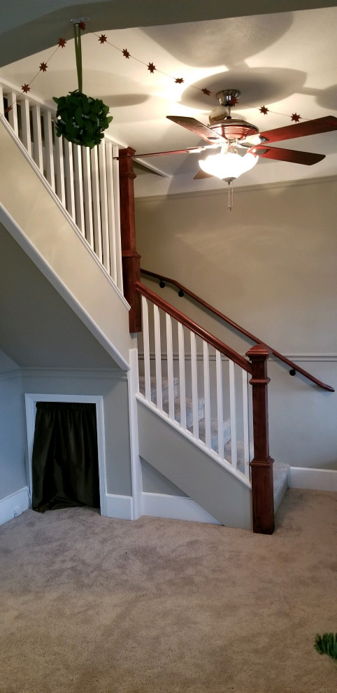 Ejemplo de escalera en L clásica de tamaño medio con escalones enmoquetados y barandilla de madera