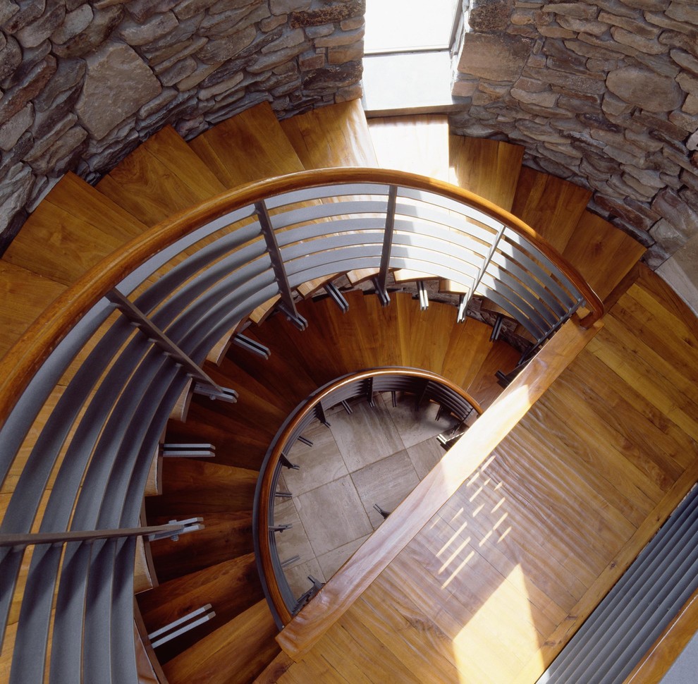 Свежая идея для дизайна: большая винтовая лестница в современном стиле с деревянными ступенями и деревянными перилами - отличное фото интерьера