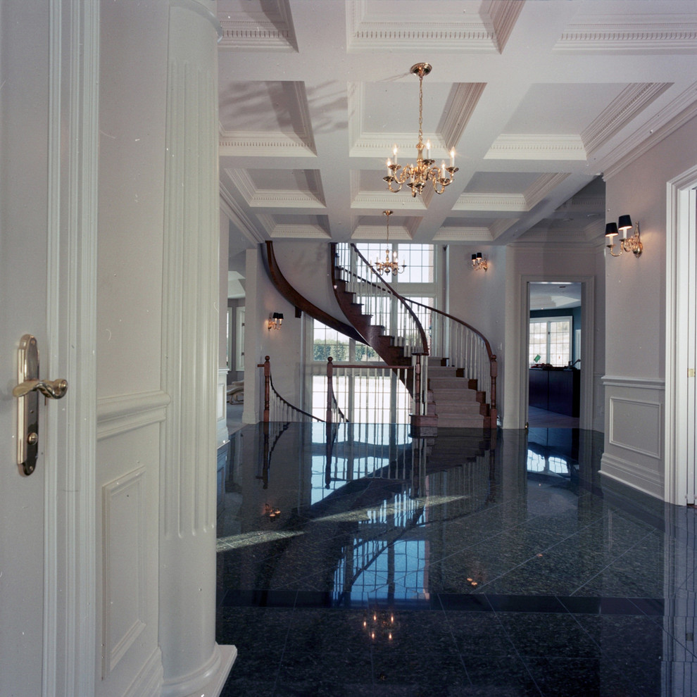 На фото: изогнутая лестница среднего размера в классическом стиле с ступенями с ковровым покрытием, ковровыми подступенками и деревянными перилами с