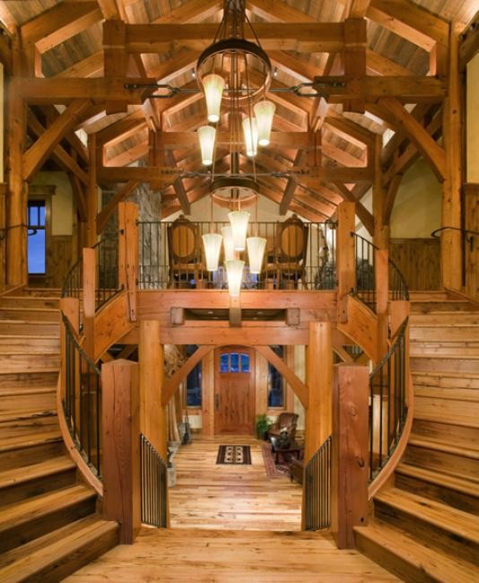 Источник вдохновения для домашнего уюта: большая изогнутая деревянная лестница в стиле рустика с деревянными ступенями и металлическими перилами