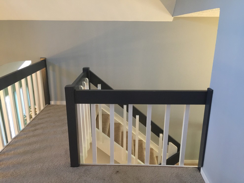 На фото: п-образная лестница среднего размера в стиле кантри с ступенями с ковровым покрытием и деревянными перилами без подступенок с