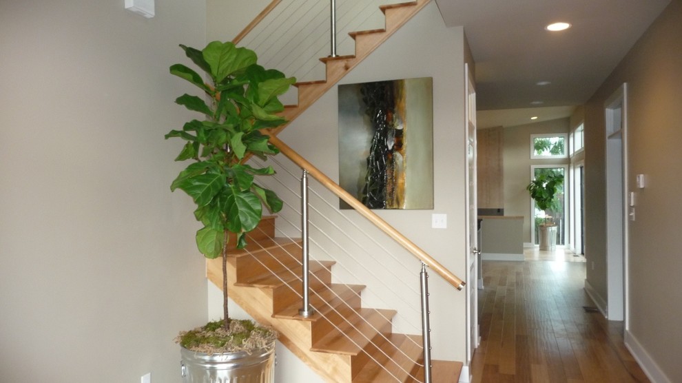 Ejemplo de escalera en U actual con escalones de madera, contrahuellas de madera y barandilla de cable