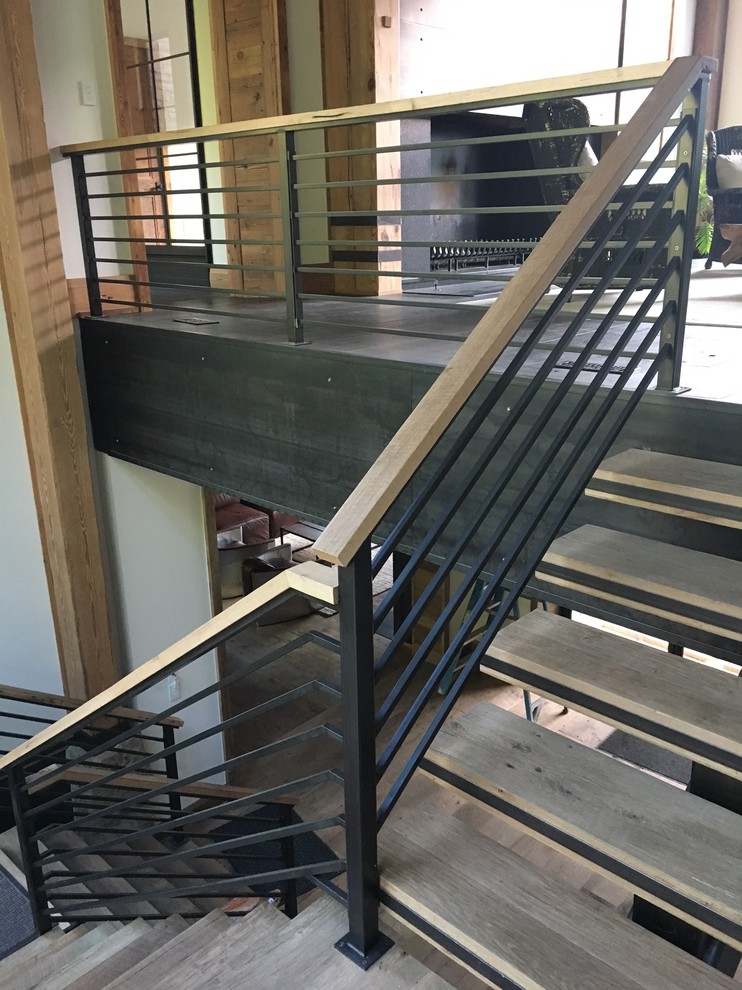 Ejemplo de escalera en L clásica renovada grande sin contrahuella con escalones de madera y barandilla de metal