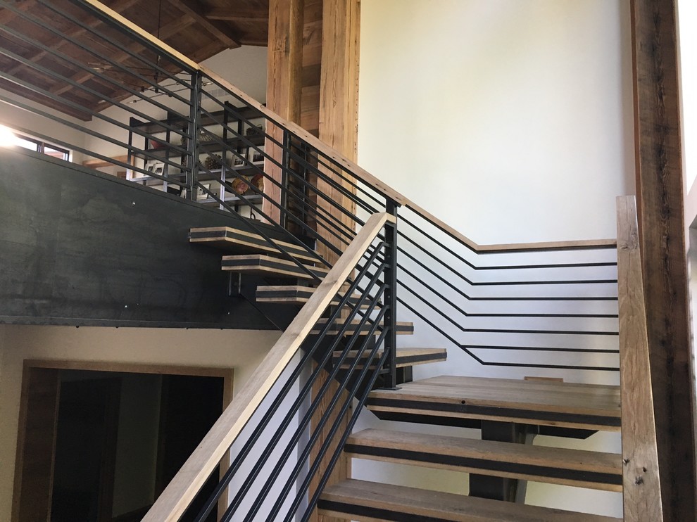 Foto de escalera en L clásica renovada grande con escalones de metal, contrahuellas de madera y barandilla de metal