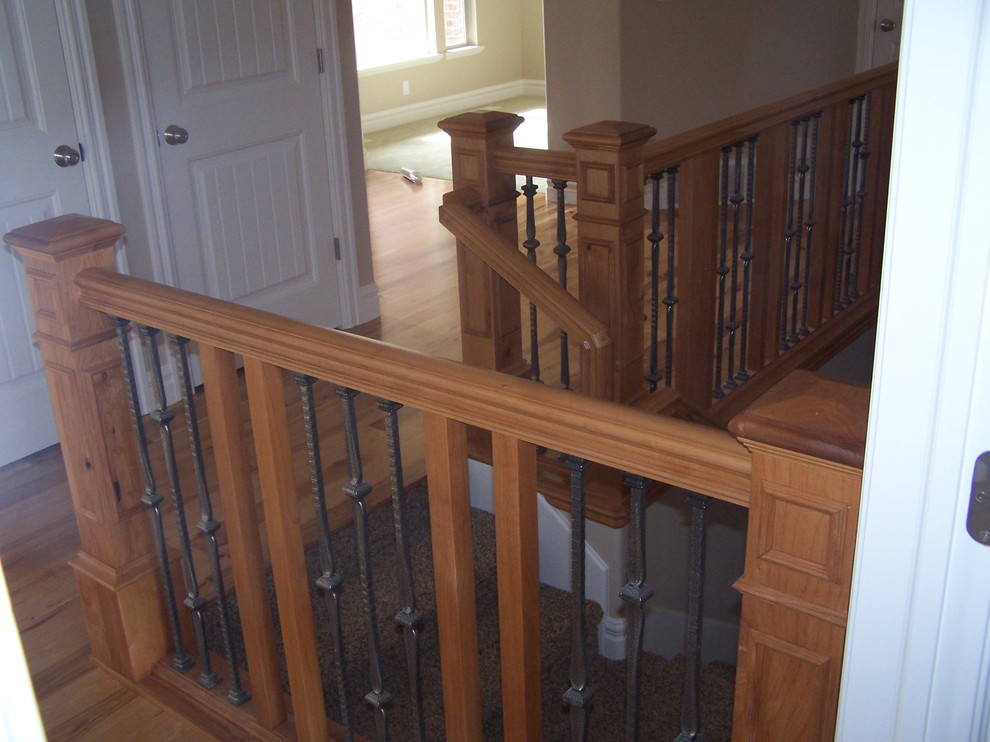 Exemple d'un escalier chic en L de taille moyenne avec des marches en moquette, des contremarches en moquette et un garde-corps en bois.
