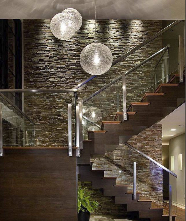 トロントにある高級な広いコンテンポラリースタイルのおしゃれな折り返し階段 (木の蹴込み板、ガラスフェンス) の写真