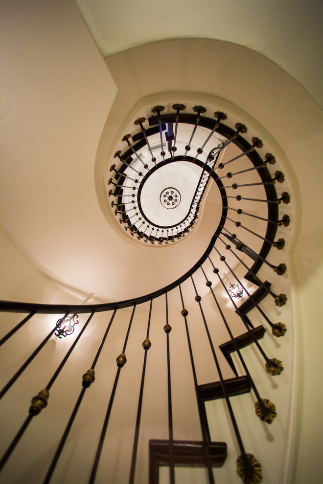 Photo of an expansive classic wood spiral metal railing staircase in Detroit.