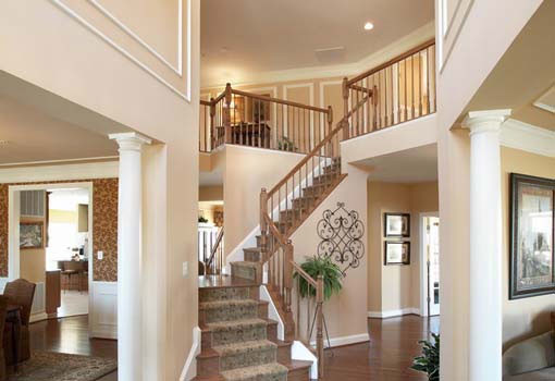 На фото: большая угловая деревянная лестница в классическом стиле с ступенями с ковровым покрытием
