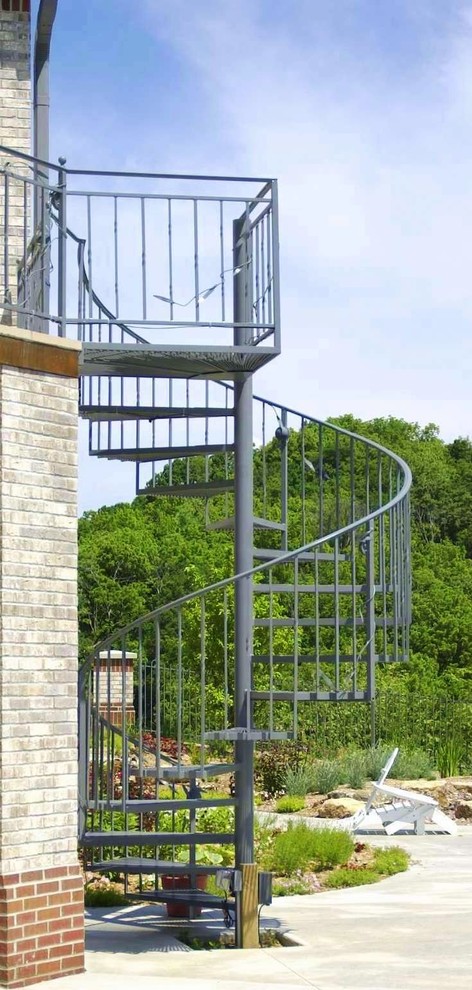 Foto de escalera de caracol actual de tamaño medio sin contrahuella con escalones de metal y barandilla de metal