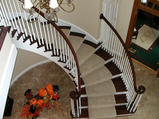 Foto de escalera curva tradicional grande con escalones de madera, contrahuellas de madera pintada y barandilla de madera