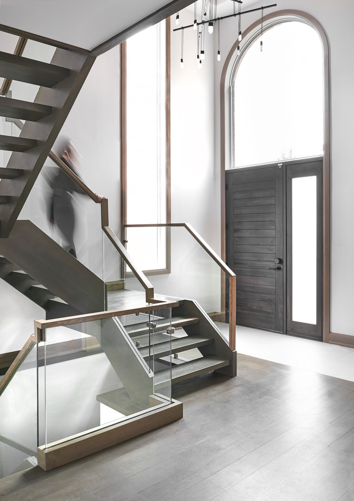 Inspiration pour un grand escalier sans contremarche flottant minimaliste avec des marches en bois et un garde-corps en bois.