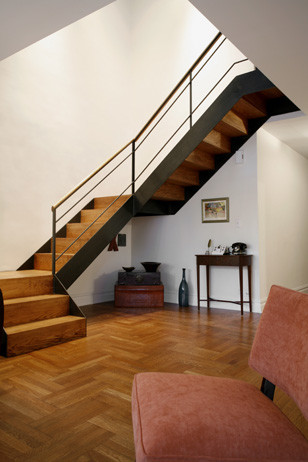 Diseño de escalera en L contemporánea de tamaño medio con escalones de madera, contrahuellas de madera y barandilla de metal